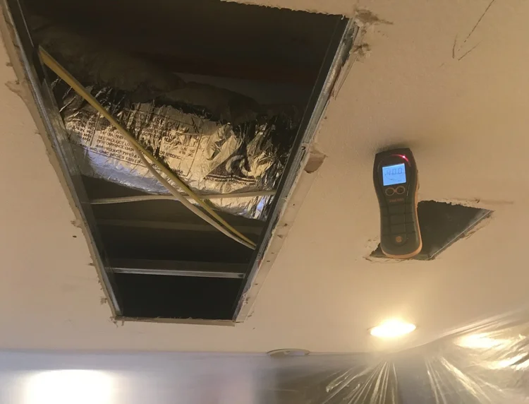 IMG_4175 Ceiling vent opening with insulation and wiring and a digital thermometer